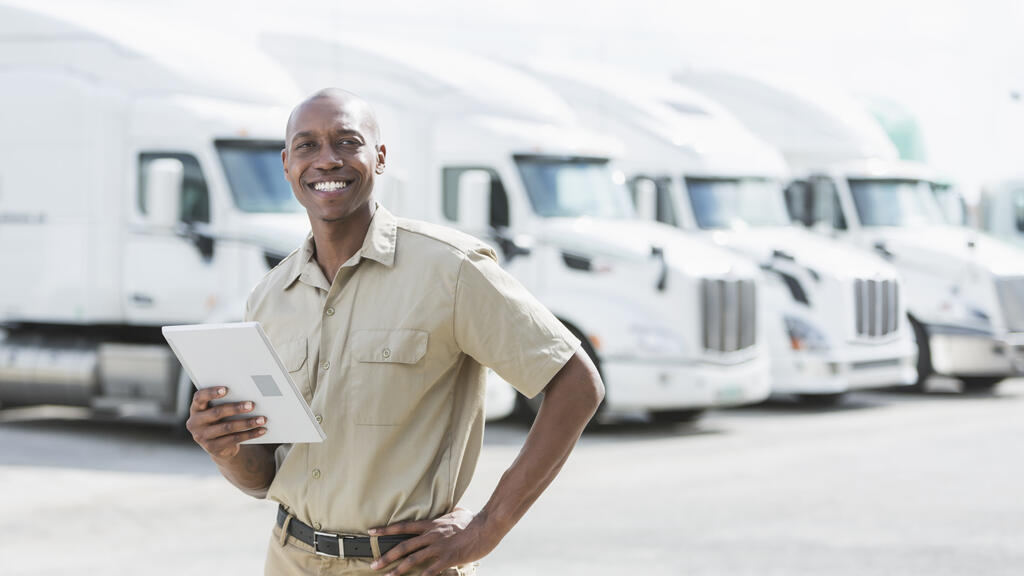 man standing in front of row of trucks